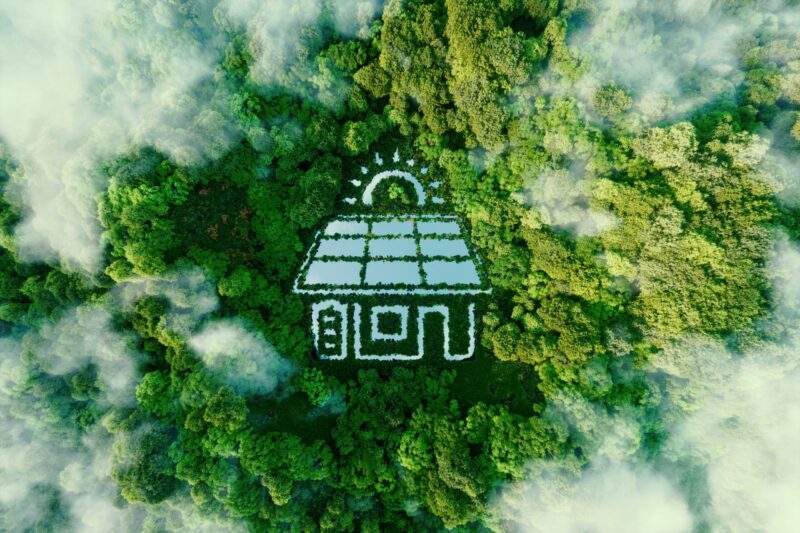 How small wind can Increase energy Independence of communities and a lake shaped like a house with solar panels on the roof, surrounded by trees.