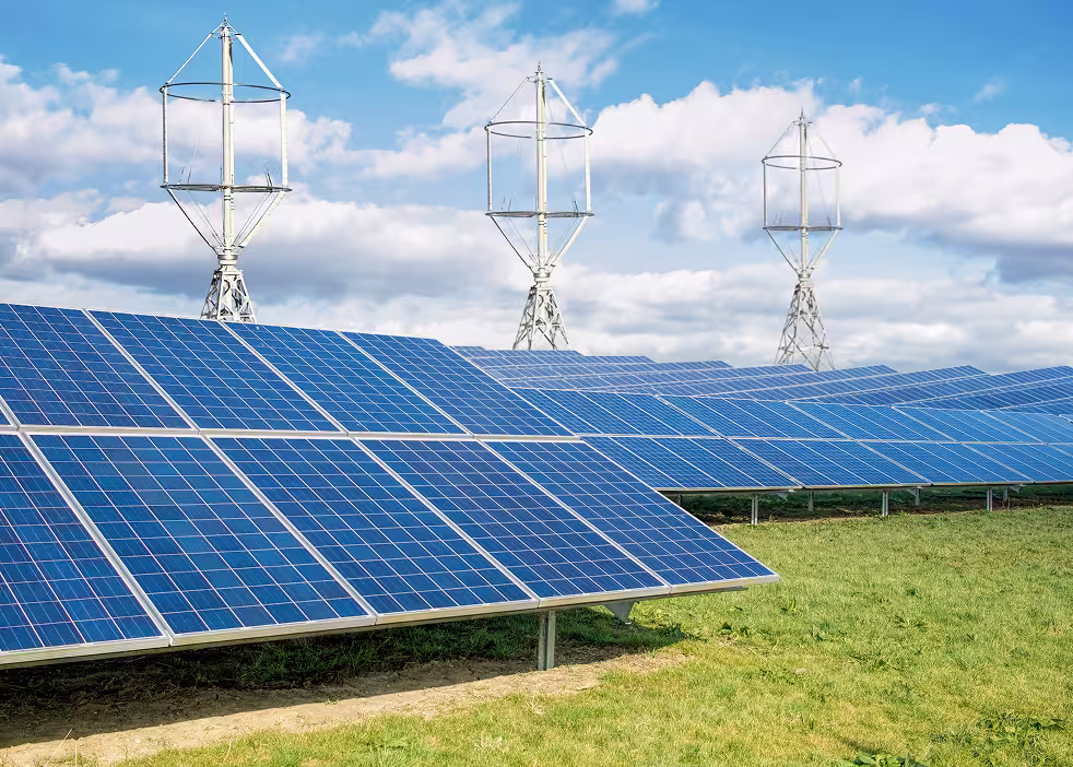 Solarmodule und vertikale Windturbinen, die gemeinsam in einem hybriden System für erneuerbare Energien arbeiten.