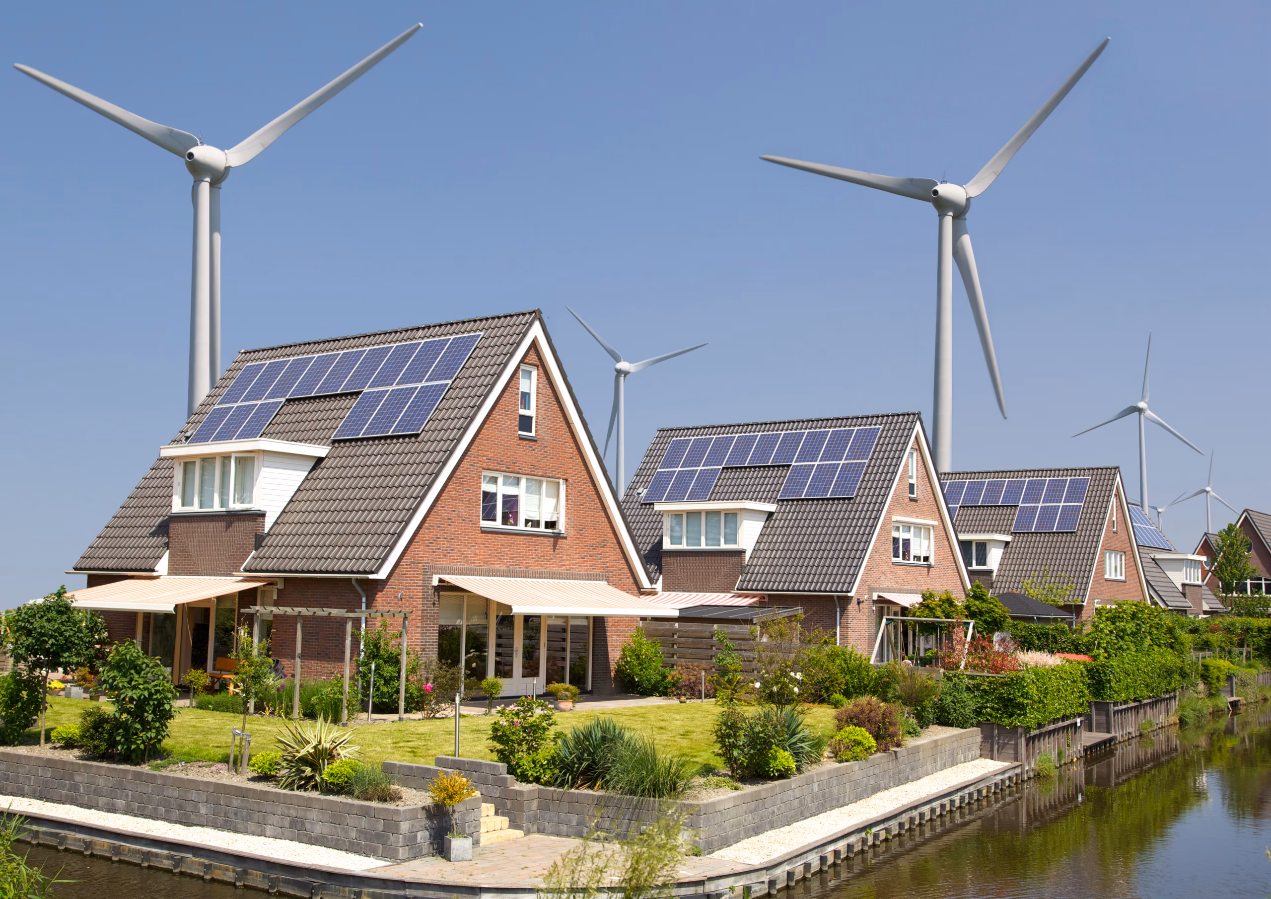 Modern houses with solar panels and wind turbines – renewable energy for residential use